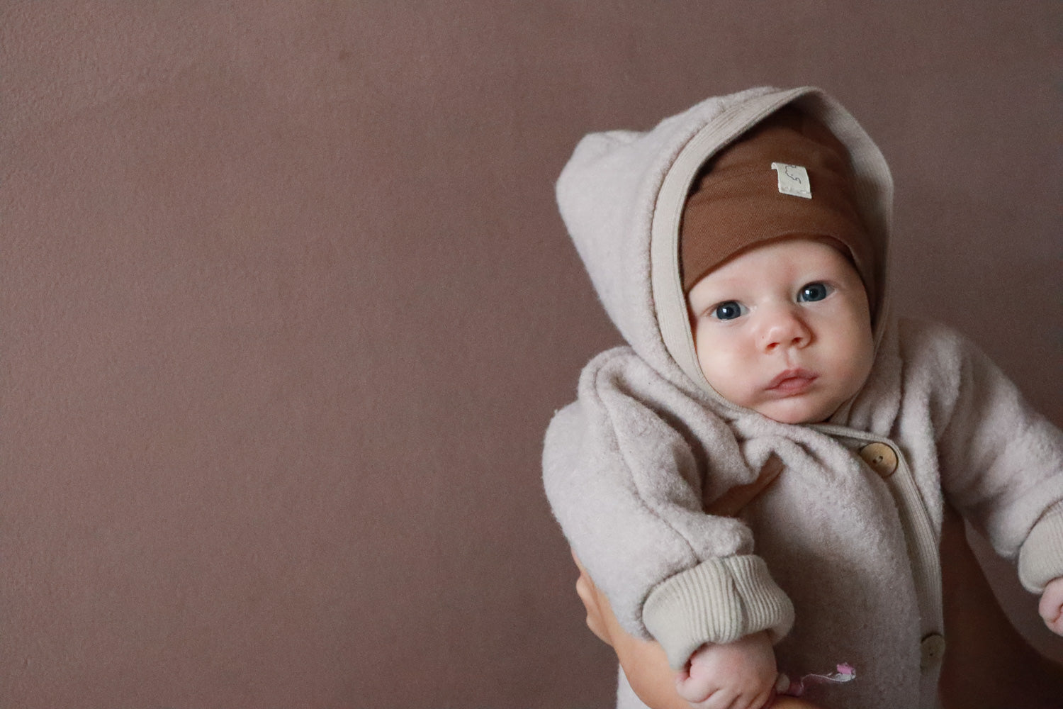 Baby mit Wollwalk Overall in der Farbe Sand