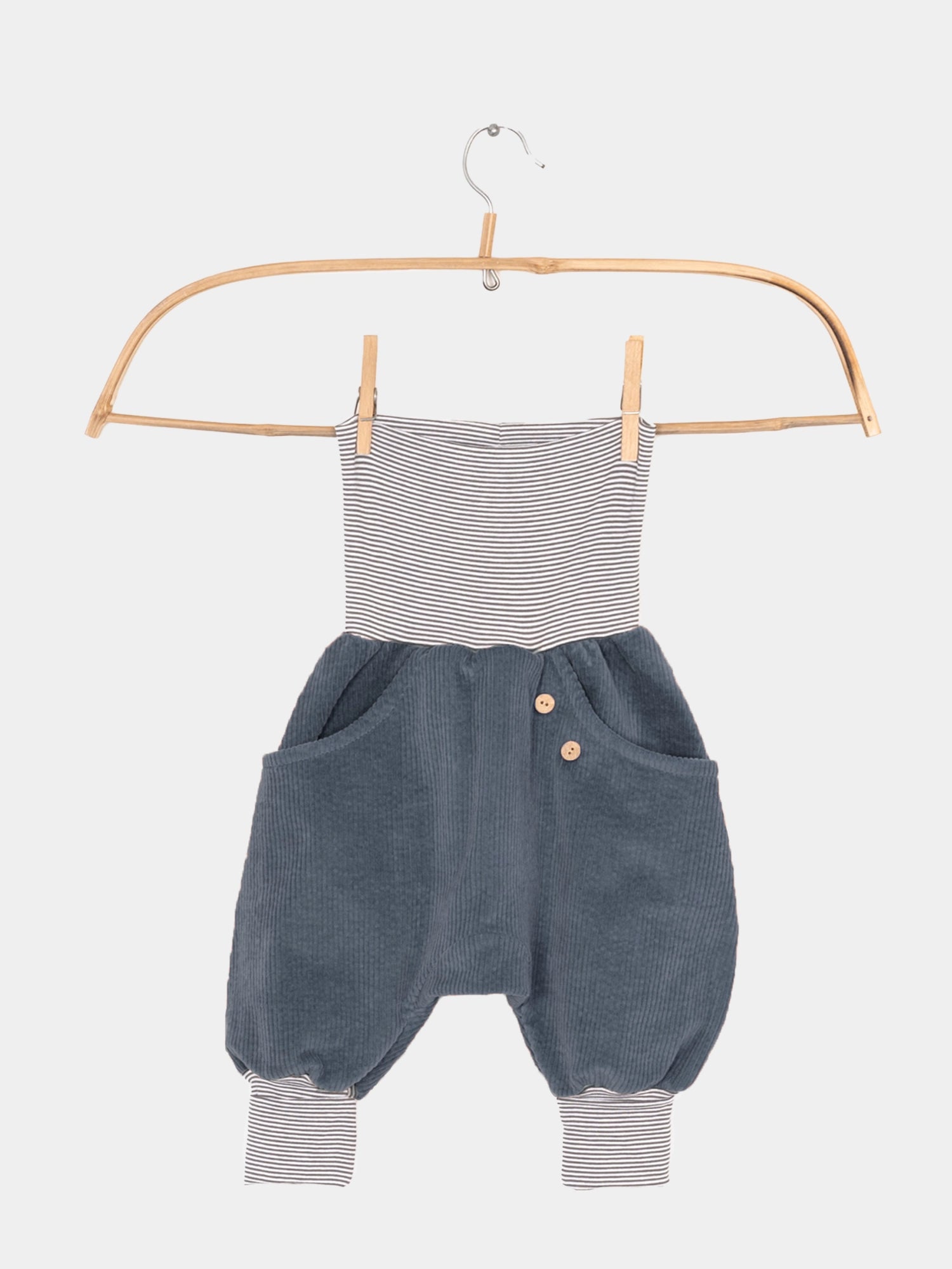 Knickerbocker Breitcord mit Ringelbündchen - Denim, auf einem Kleiderbügel hängend. Robuster Cordstoff mit bequemen, elastischen Bündchen und großer Känguru-Tasche für Kinder.