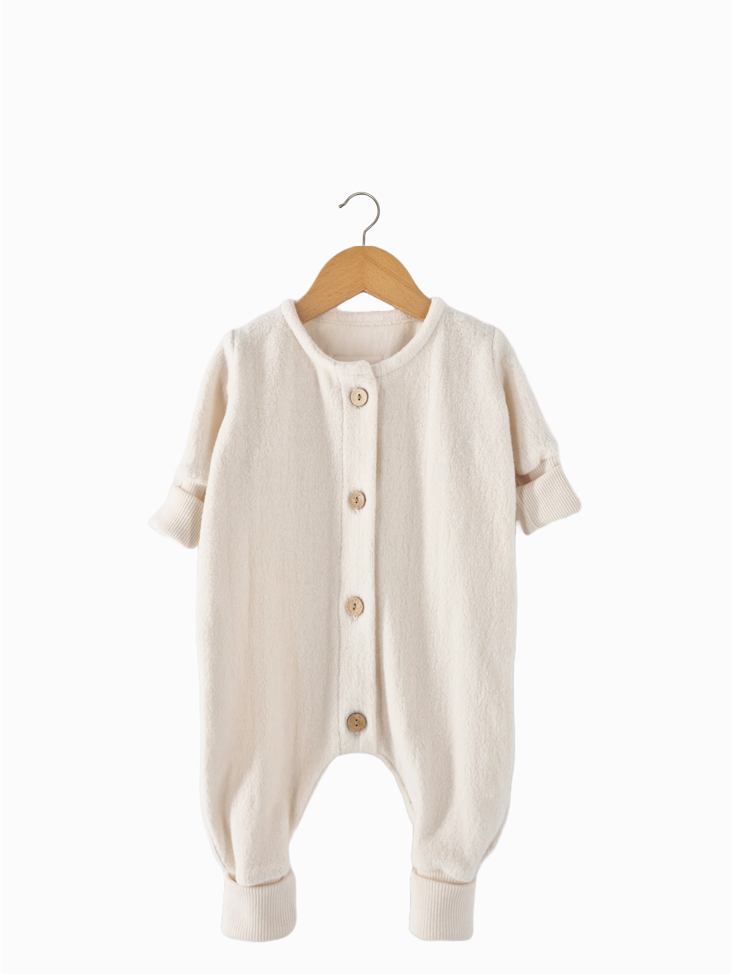 Baby Overall/Schlafanzug aus feinem Bio-Teddy - Natur auf einem Holzbügel, zeigt weißen Romper mit Knöpfen, handgenäht aus temperaturausgleichendem Bio-Baumwoll-Teddy.